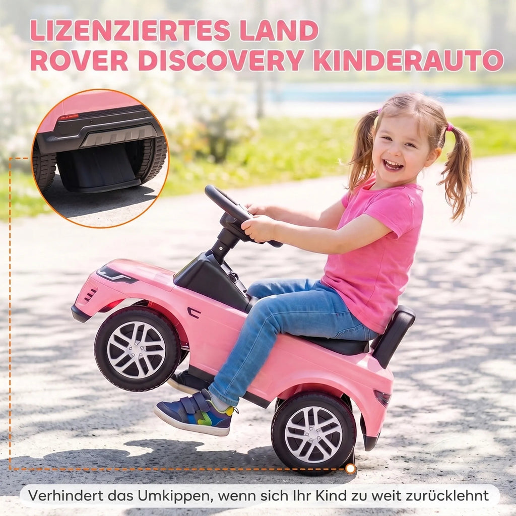 Sėdėdama ant rožinio automobiliuko mergaitė šypsosi lauke