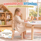 Mergaitė sėdi ant kėdės piešdama prie balto stalo šviesiame kambaryje