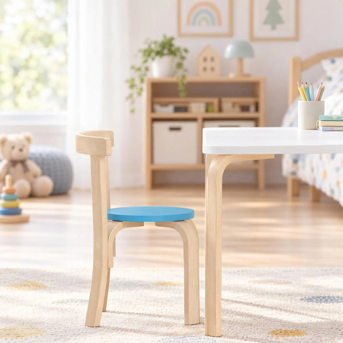 Medinė kėdė su mėlyna sėdyne pastatyta šalia stalo vaikų kambaryje