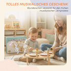 Mama su vaikučiu žaidžia muzikos instrumentų staliuku šalia pakuotės dėžės