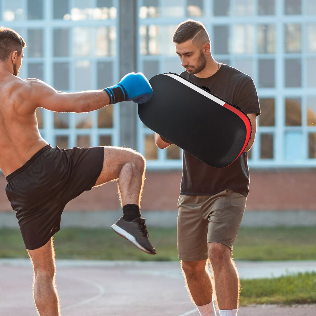 Vyrai treniruojasi su smūgių pagalve lauke
