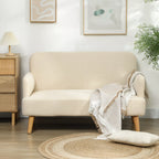 Kreminė balta dvivietė sofa su pledu kambaryje