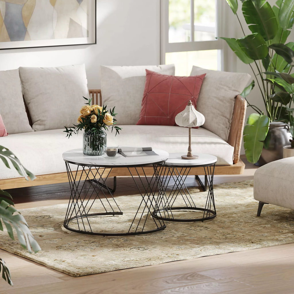 Du sudėti balti apvalūs kavos staliukai šviesioje svetainėje