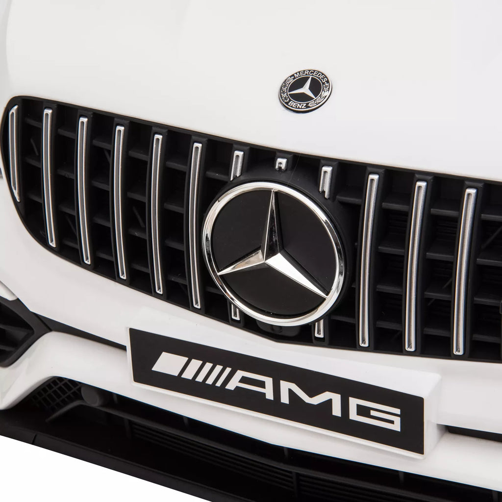 Balto elektromobilio Mercedes emblema ant grotelių iš arti