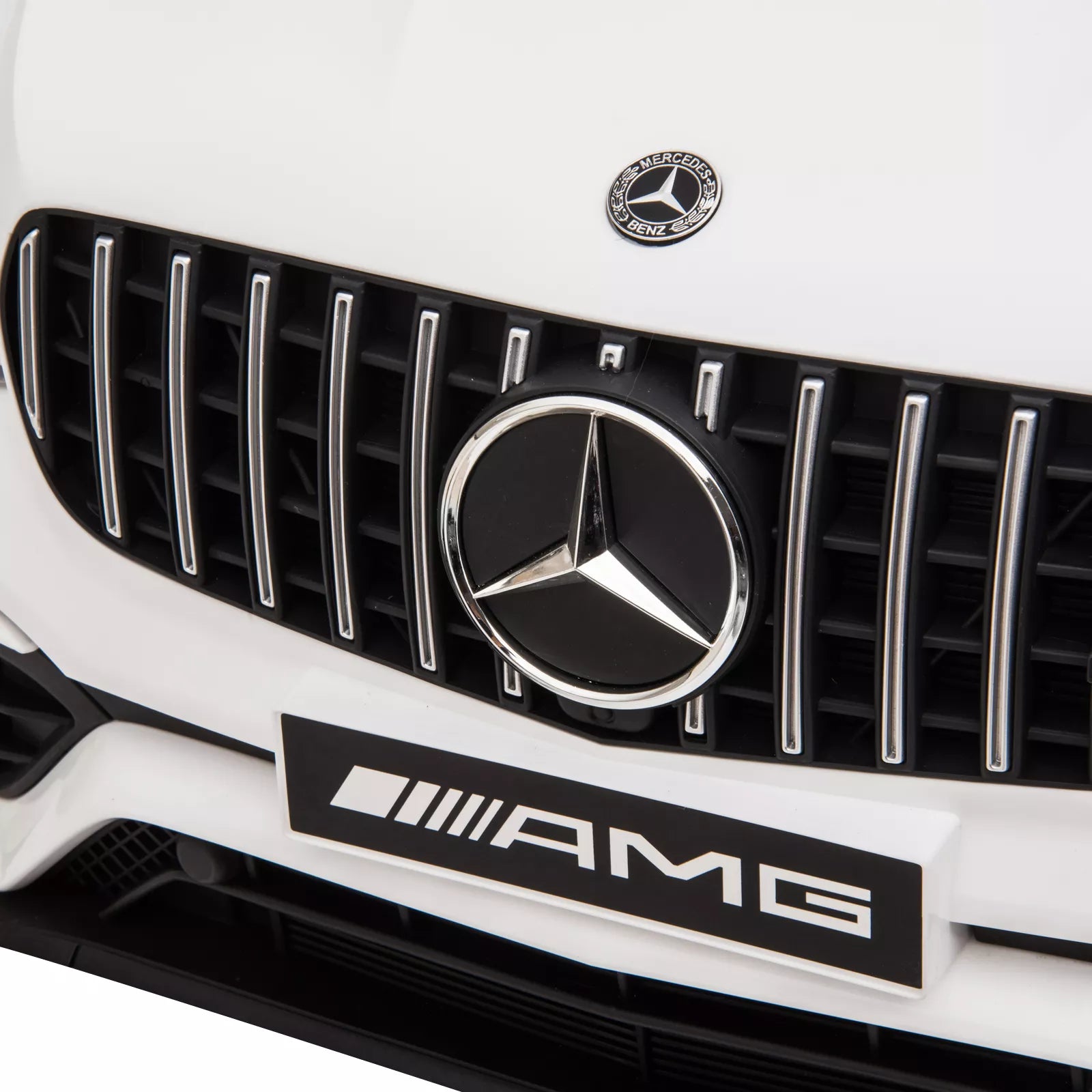 Balto elektromobilio Mercedes emblema ant grotelių iš arti